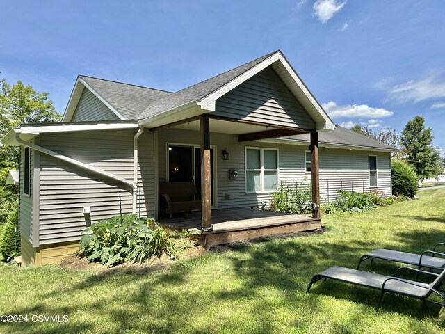 view of front facade with a deck and a front lawn