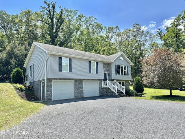 split foyer home featuring a garage and a front lawn