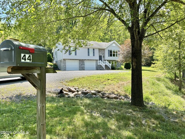 raised ranch featuring a garage and a front yard