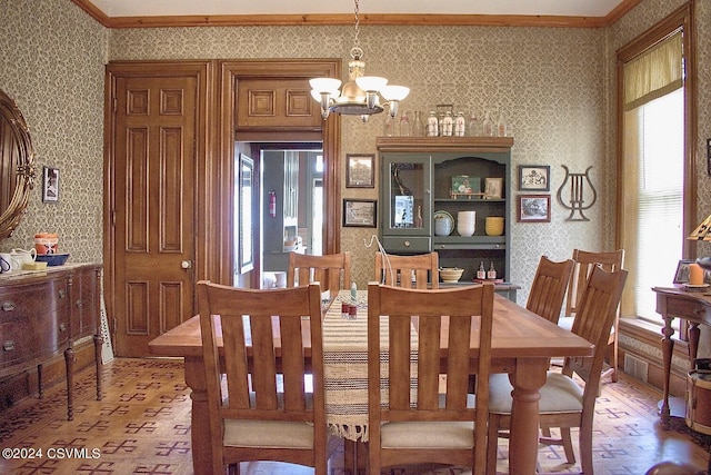 dining area with hardwood / wood-style flooring, a chandelier, and crown molding