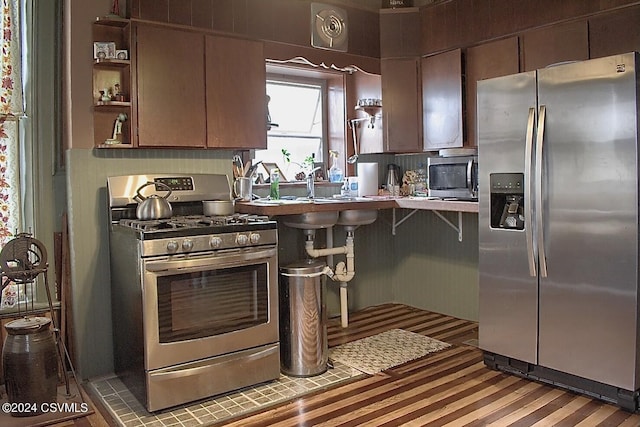 kitchen with a kitchen breakfast bar, decorative backsplash, sink, and stainless steel appliances