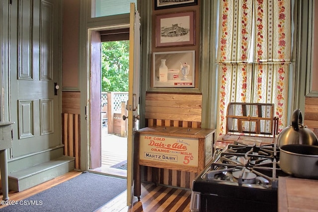 doorway to outside with wood-type flooring and wooden walls