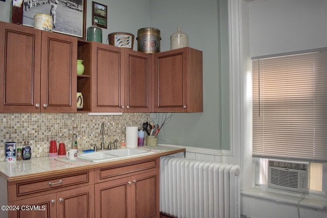 kitchen featuring radiator, tile countertops, cooling unit, backsplash, and sink