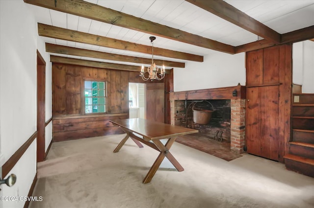 living room featuring beam ceiling, carpet floors, wood walls, and a chandelier