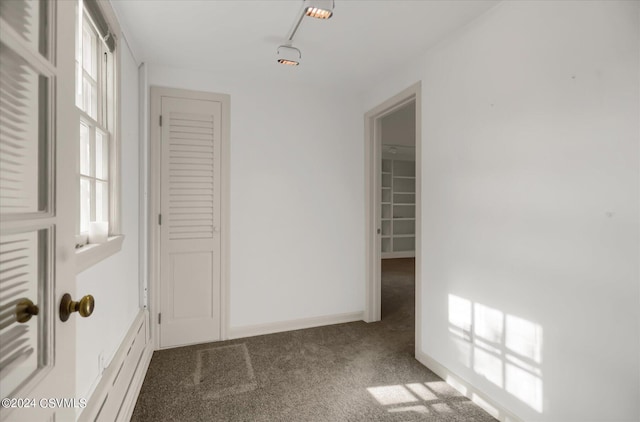 carpeted spare room featuring track lighting