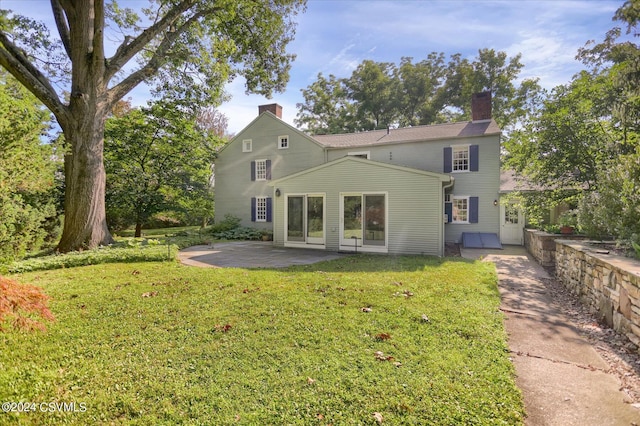 back of house with a patio area and a yard