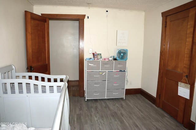 bedroom featuring dark hardwood / wood-style flooring and a textured ceiling