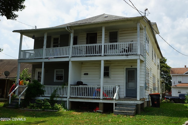 view of front facade featuring a porch, a balcony, and a front lawn