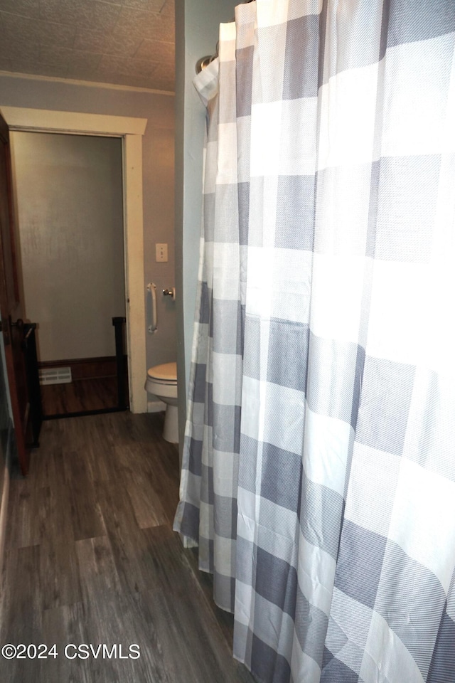 bathroom with toilet and hardwood / wood-style floors