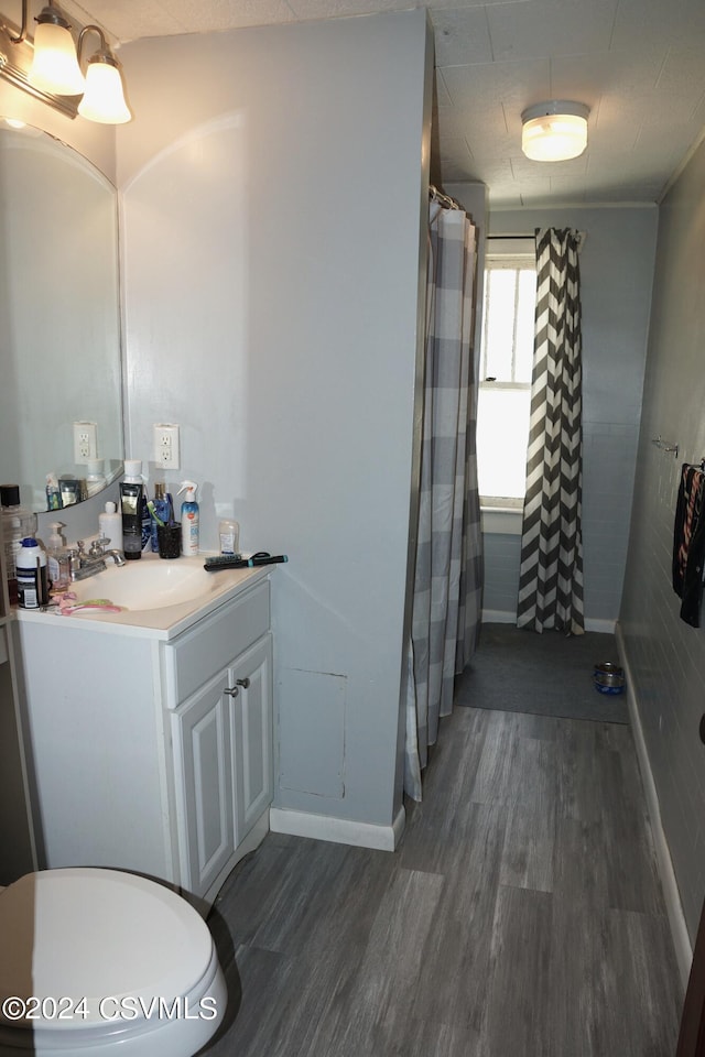 bathroom with vanity, toilet, and hardwood / wood-style floors