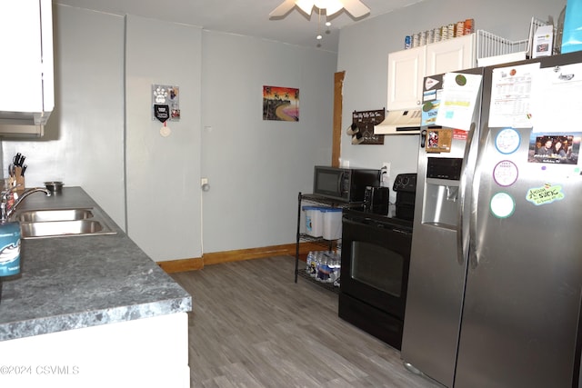 kitchen with white cabinets, premium range hood, ceiling fan, black appliances, and hardwood / wood-style floors