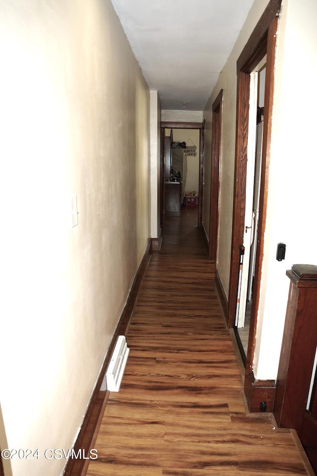 corridor with dark hardwood / wood-style flooring