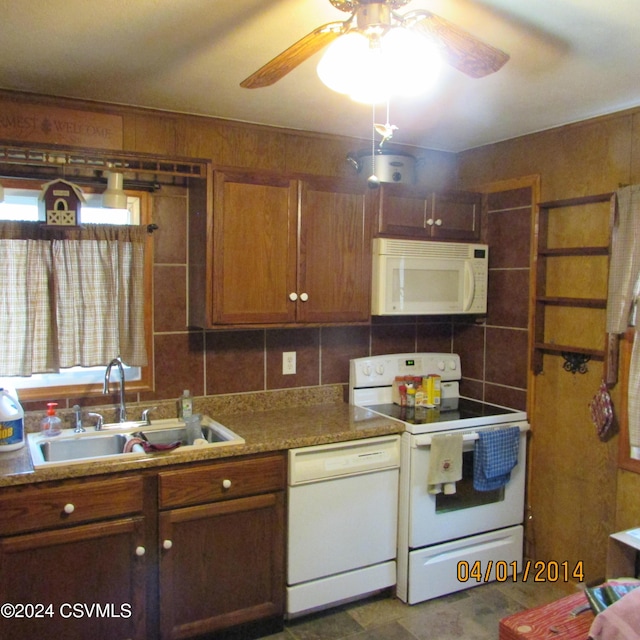 kitchen with a wealth of natural light, brown cabinets, white appliances, tile walls, and a sink