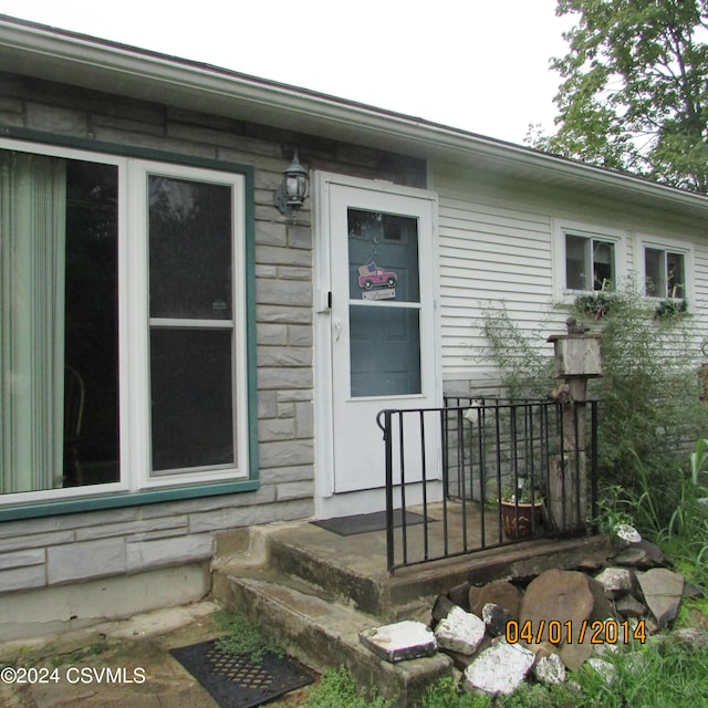 doorway to property featuring stone siding