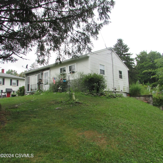 rear view of house featuring a lawn