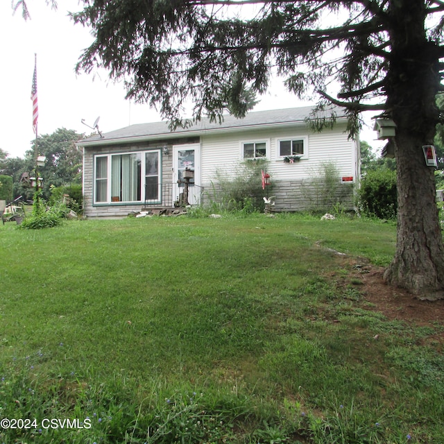 rear view of house featuring a lawn