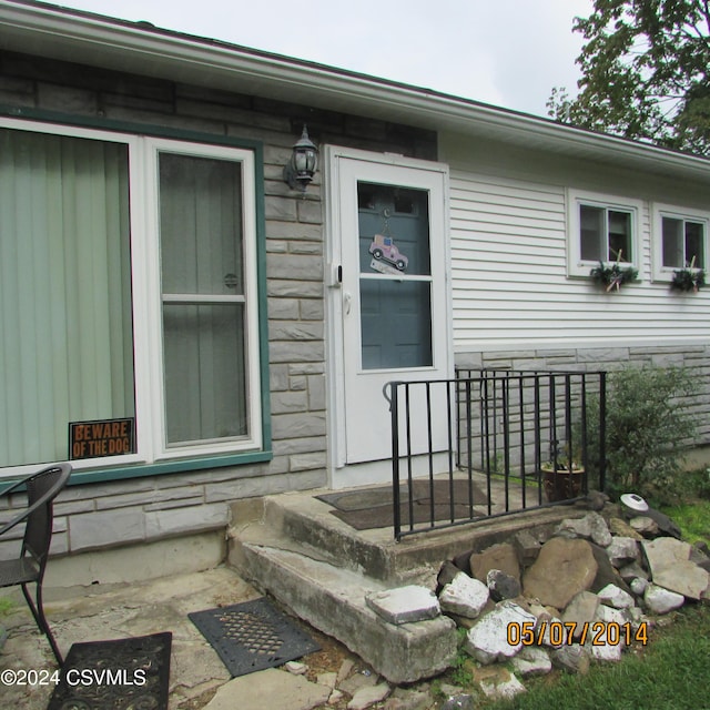 view of exterior entry featuring stone siding