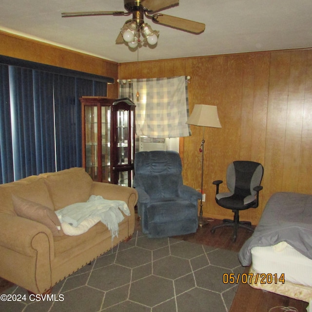 living area featuring wood walls and ceiling fan