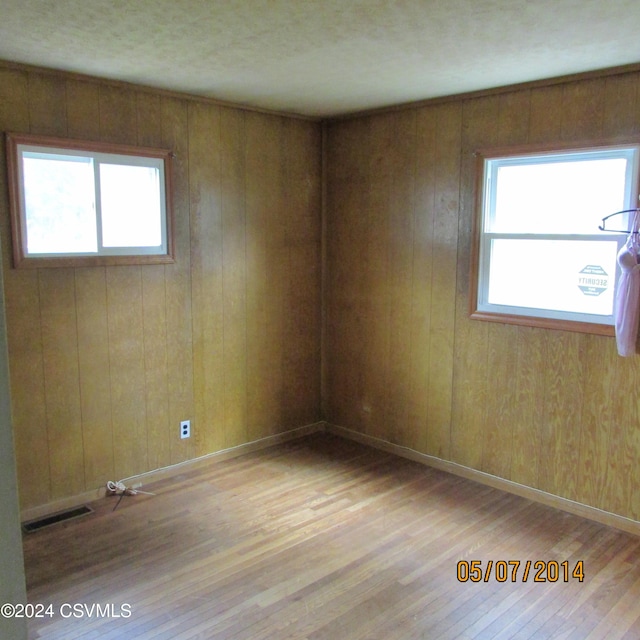 unfurnished room with visible vents, baseboards, and wood finished floors