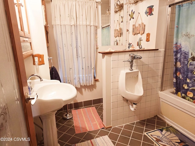 bathroom featuring shower / bath combo with shower curtain, tile patterned flooring, and tile walls