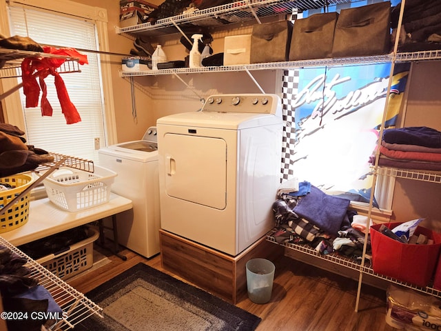 clothes washing area with washer and dryer and hardwood / wood-style floors