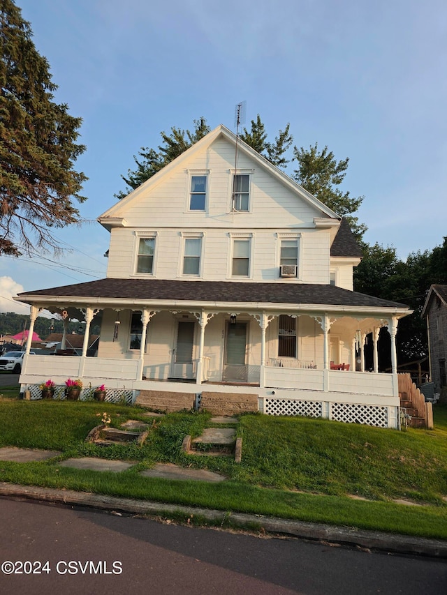 farmhouse with a porch and a front lawn