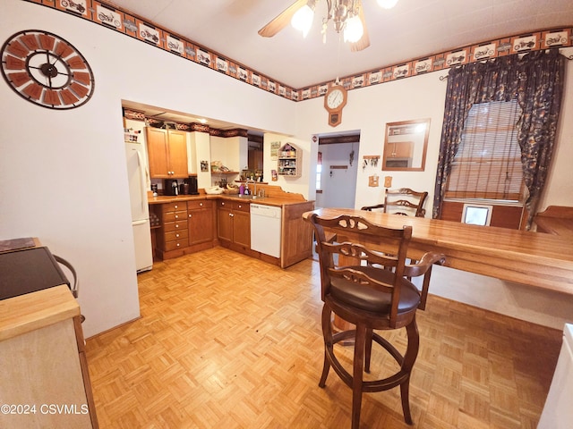 kitchen with light parquet floors, ceiling fan, sink, and white appliances