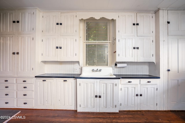 kitchen with sink, white cabinetry, and wood-type flooring