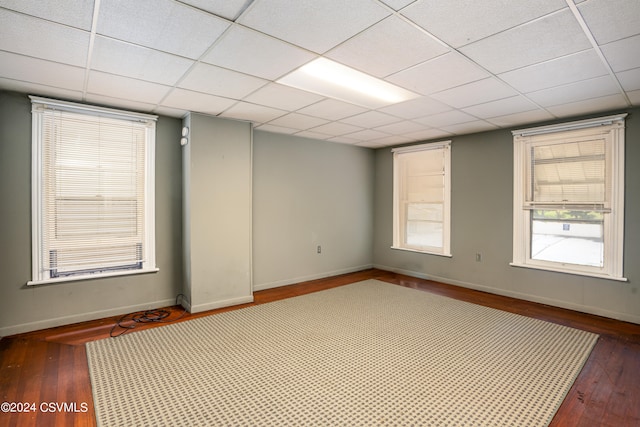 spare room featuring wood-type flooring and a drop ceiling