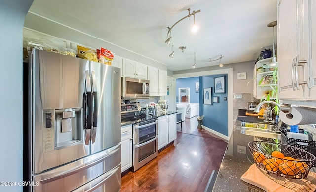 kitchen featuring stainless steel appliances, white cabinets, rail lighting, sink, and dark hardwood / wood-style floors