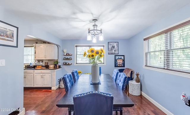 dining area with an inviting chandelier and dark wood-type flooring