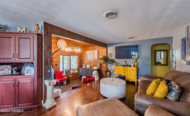 living room with wood walls and dark wood-type flooring