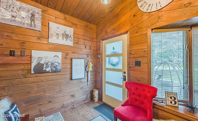 sitting room with wood ceiling and wood walls