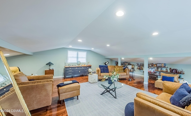 living room featuring dark hardwood / wood-style floors, vaulted ceiling, and ornate columns