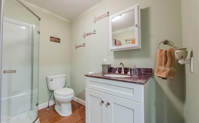 bathroom with hardwood / wood-style floors, walk in shower, toilet, and vanity