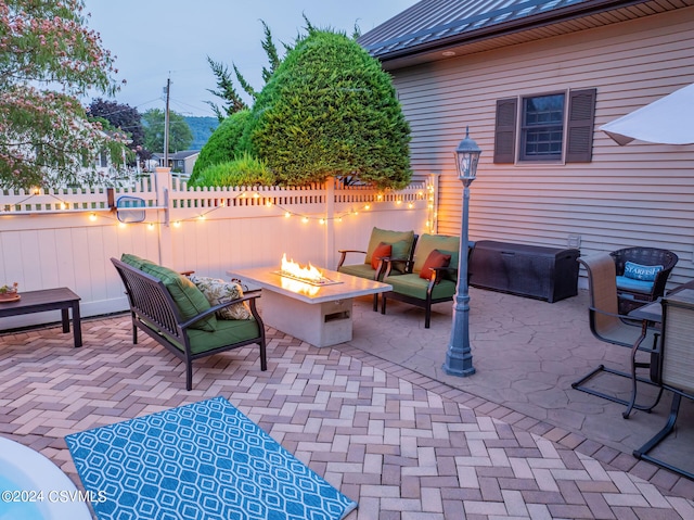 patio terrace at dusk featuring an outdoor living space with a fire pit