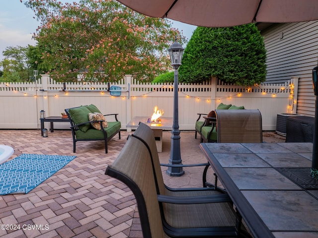 view of patio / terrace featuring cooling unit and a fire pit