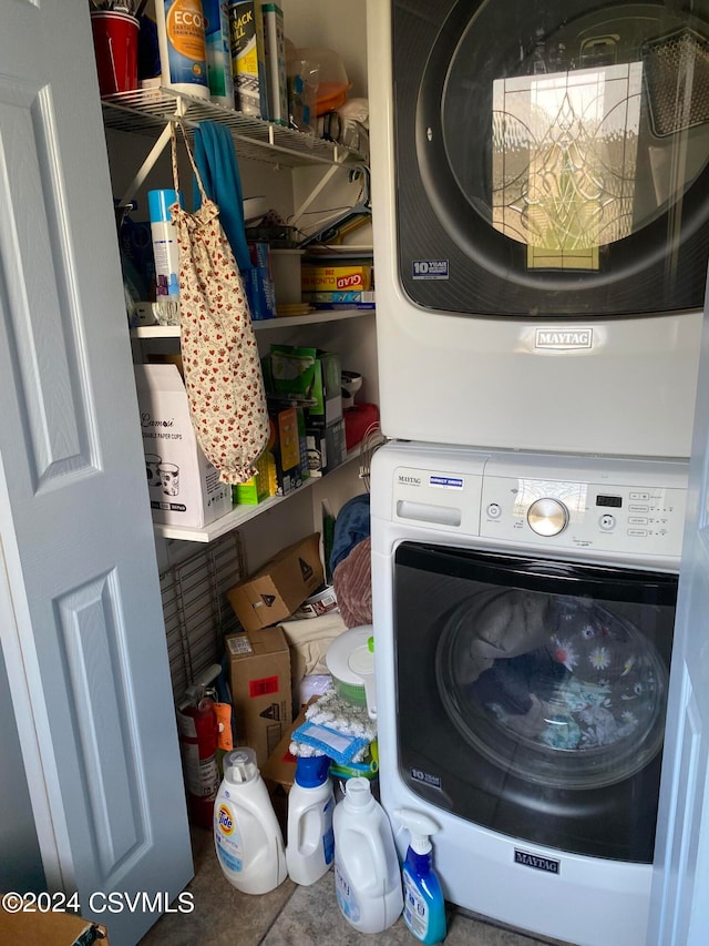 clothes washing area with tile patterned flooring and stacked washer and dryer