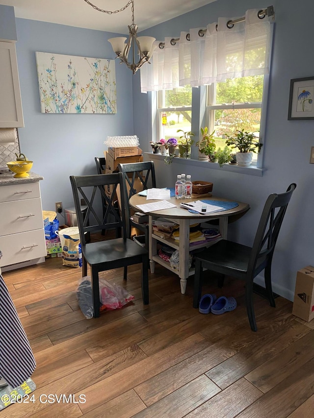 dining space featuring hardwood / wood-style floors and an inviting chandelier