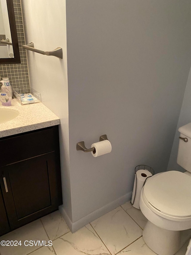 bathroom with toilet, vanity, and tile patterned floors