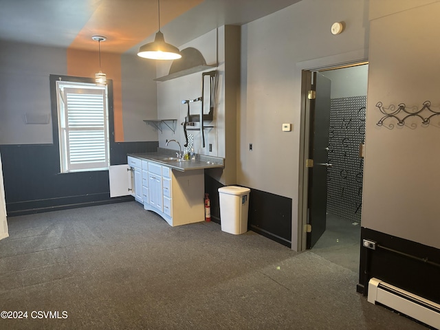 kitchen with dark carpet, baseboard heating, pendant lighting, sink, and white cabinetry