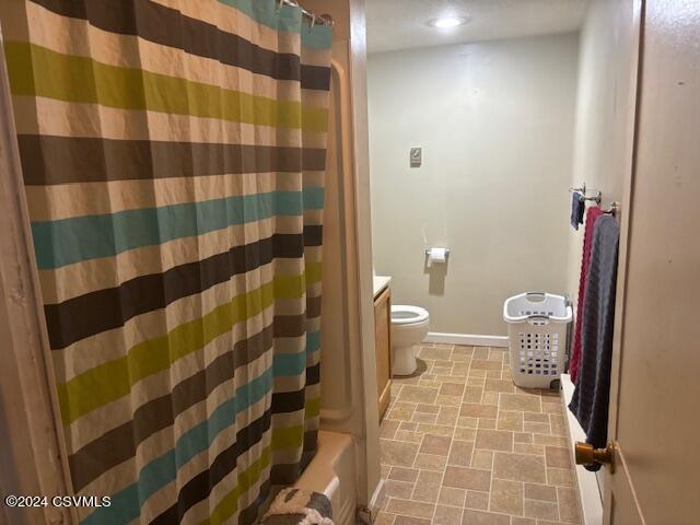 full bathroom with toilet, vanity, and shower / bath combination with curtain