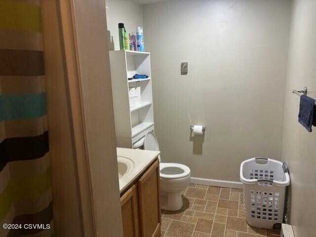 bathroom with a baseboard heating unit, toilet, and vanity