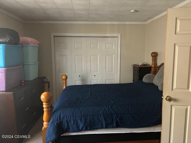 bedroom with crown molding and a closet