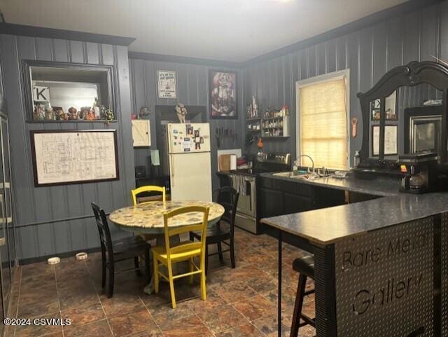 kitchen featuring white refrigerator, sink, and stainless steel electric stove