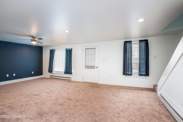 carpeted empty room featuring plenty of natural light, ceiling fan, and baseboard heating