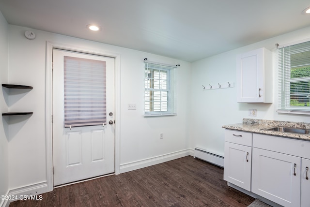 doorway to outside with baseboard heating, dark hardwood / wood-style flooring, and sink