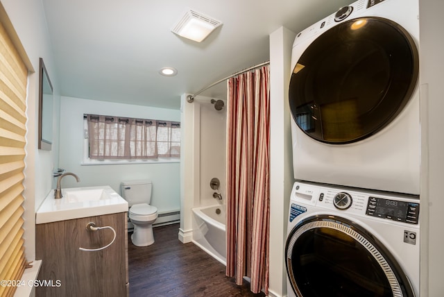 clothes washing area with a baseboard radiator, stacked washer and clothes dryer, sink, and dark wood-type flooring