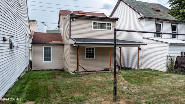 rear view of house featuring a yard