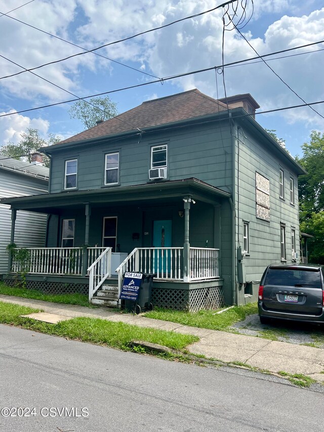 view of front facade with cooling unit and covered porch